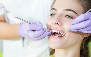 A woman getting her teeth checked by a dentist